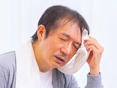 顔が火照って汗をかく男性