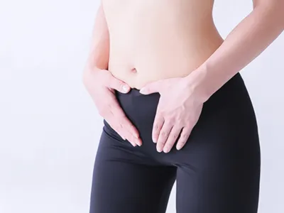 股間を押さえる女性
